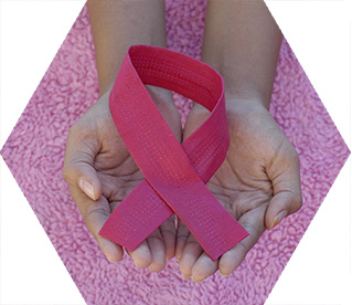 photo - closeup of someone's hands holding a pink ribbon