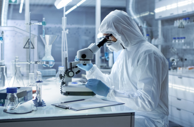 Photo – A scientist in a lab looking through a microscope