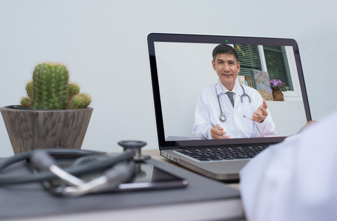 photo – a doctor delivering a presentation via a laptop to someone watching