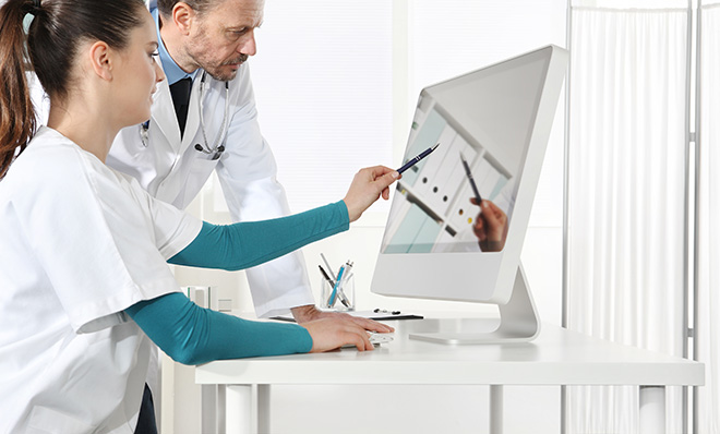 photo – healthcare professionals use a touch screen in a clinic